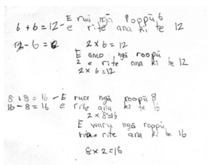 A student's workings on a maths problem, including numbers, symbols and text in te reo